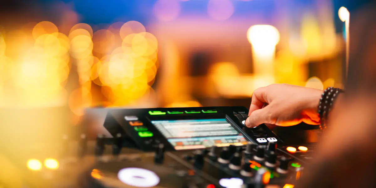 DJ adjusting mixer with lights.